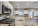 Well-equipped kitchen with gas cooktop, granite countertops, white cabinets, and an island for dining at 7010 S San Jacinto Ct, Gilbert, AZ 85298