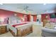 Well-lit main bedroom with a ceiling fan, accent wall, and a comfortable seating area with a sofa at 7010 S San Jacinto Ct, Gilbert, AZ 85298