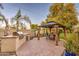 Outdoor kitchen with built-in grill and prep area next to dining gazebo and lush backyard at 7010 S San Jacinto Ct, Gilbert, AZ 85298