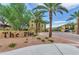 Inviting community entrance with stone signage, lush landscaping and palm trees lining the roadway at 7130 W Linda Ln, Chandler, AZ 85226