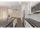 Open concept kitchen with a black countertop island, white cabinets and stainless appliances at 7130 W Linda Ln, Chandler, AZ 85226