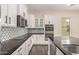 Well-lit modern kitchen with stainless appliances, white cabinets, and black countertops at 7130 W Linda Ln, Chandler, AZ 85226