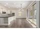 Light-filled kitchen with wood floors, stainless appliances, island, and sliding glass doors to the patio at 7130 W Linda Ln, Chandler, AZ 85226