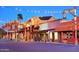 Charming street view lined with quaint buildings adorned with vintage lights against a twilight sky at 7151 E Rancho Vista Dr # 1017, Scottsdale, AZ 85251