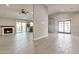 Bright living room featuring a brick fireplace, light grey tile flooring, and access to the kitchen at 726 E Aire Libre Ave, Phoenix, AZ 85022