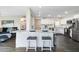 Open kitchen layout with granite countertop island, white cabinetry, dark wood floors, and barstool seating at 790 N Meadows Dr, Chandler, AZ 85224