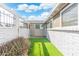 A serene side yard featuring artificial turf and a white brick fence at 790 N Meadows Dr, Chandler, AZ 85224