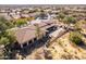 Aerial view of a home with a patio, desert landscaping and mature trees at 8142 S Open Trail Ln, Gold Canyon, AZ 85118