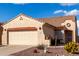 Home exterior with two-car garage, tan stucco, and attractive desert landscaping at 8142 S Open Trail Ln, Gold Canyon, AZ 85118