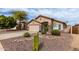 This desert home features a two-car garage and xeriscaping with mature trees, cacti and shrubbery at 8204 W Tonto Ln, Peoria, AZ 85382