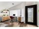 Bright home office with wood floors, modern furniture, shelving, and an ornate glass front door at 8204 W Tonto Ln, Peoria, AZ 85382