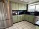 Kitchen featuring stainless steel appliances, ample cabinet space, black countertops and tile flooring at 8410 N 32Nd Ave, Phoenix, AZ 85051