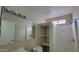 Clean bathroom featuring a mirrored vanity, toilet, and shower space with built-in shelving at 8815 W Columbus Ave, Phoenix, AZ 85037