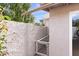 Exterior stucco wall and gated dog run, surrounded by green trees and landscaping at 934 E Cochise Dr, Phoenix, AZ 85020