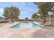 Community pool with lounge chairs and umbrellas surrounded by well maintained landscaping and fencing at 934 E Cochise Dr, Phoenix, AZ 85020