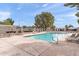 Community pool with lounge chairs and umbrellas surrounded by well maintained landscaping and fencing at 934 E Cochise Dr, Phoenix, AZ 85020