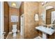 Half-bathroom showcasing a pedestal sink, patterned wallpaper, decorative mirror, and a standard toilet at 964 S Henry Ln, Gilbert, AZ 85296