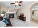 Living room showcasing a stone fireplace, leather sofa, ceiling fan, and an arched doorway to another room at 964 S Henry Ln, Gilbert, AZ 85296