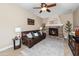 Cozy living room with a stone fireplace, ceiling fan, and comfortable seating at 964 S Henry Ln, Gilbert, AZ 85296