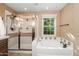 Main bathroom features a glass shower, bathtub, window and neutral tile at 964 S Henry Ln, Gilbert, AZ 85296