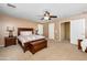 This spacious main bedroom features warm neutral colors, a ceiling fan, a wooden bed and a window with shutters at 964 S Henry Ln, Gilbert, AZ 85296