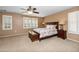 Spacious bedroom features a beautiful patterned bedspread, ceiling fan, and bright, shuttered windows at 964 S Henry Ln, Gilbert, AZ 85296