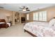 Large main bedroom features an ensuite bathroom, a leather chair and a ceiling fan at 964 S Henry Ln, Gilbert, AZ 85296