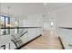 Hallway with sleek glass railings, modern lighting and light hardwood floors at 100 W Northern Ave # 13, Phoenix, AZ 85021