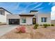 Contemporary home featuring a minimalist design, black-trimmed windows, and a well-maintained gravel yard with flowering bushes at 100 W Northern Ave # 17, Phoenix, AZ 85021