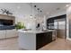 Open kitchen featuring a large island, modern appliances, dark cabinetry, and seamless connection to the living area at 100 W Northern Ave # 17, Phoenix, AZ 85021