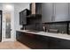 Stylish kitchen with black cabinets, stainless steel hood, and quartz countertops at 100 W Northern Ave # 17, Phoenix, AZ 85021