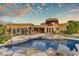 Luxury backyard featuring a pool, fire pit, and lush landscaping under a beautiful sunset sky at 10396 N 133Rd St, Scottsdale, AZ 85259