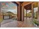 Covered porch with wood beams and stone flooring, offering scenic views of the surrounding landscape at 10396 N 133Rd St, Scottsdale, AZ 85259
