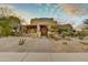 Expansive desert home with mature landscaping, decorative plants, and a winding stone walkway at 10396 N 133Rd St, Scottsdale, AZ 85259
