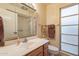 Bathroom featuring a vanity, framed mirror, and a walk in shower at 10726 W Pineaire Dr, Sun City, AZ 85351