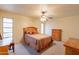 Cozy bedroom with carpet, a ceiling fan, and wooden furniture at 10726 W Pineaire Dr, Sun City, AZ 85351