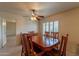 Dining room featuring wood table, ceiling fan, and a window with plantation shutters at 10726 W Pineaire Dr, Sun City, AZ 85351