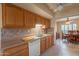 Well-organized kitchen with oak cabinets and a view to the adjacent dining area at 10726 W Pineaire Dr, Sun City, AZ 85351