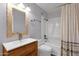 Bright bathroom featuring a wood framed mirror, and a shower with a tub, offering a clean and modern space at 1210 E Harmony Cir, Mesa, AZ 85204