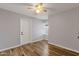 Bedroom features wood flooring, neutral paint, ceiling fan, and exterior door at 1210 E Harmony Cir, Mesa, AZ 85204