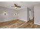 Spacious bedroom featuring ceiling fan, wood floors, neutral walls, and modern sconces at 1210 E Harmony Cir, Mesa, AZ 85204