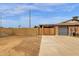 Exterior view of the property, with gated driveway and garage, with desert landscaping, under a bright sky at 1210 E Harmony Cir, Mesa, AZ 85204
