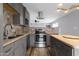 Well-lit kitchen with stainless steel appliances, gray cabinetry, beautiful backsplash, and a kitchen island at 1210 E Harmony Cir, Mesa, AZ 85204