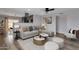 Bright living room featuring a comfortable gray sofa, stylish decor, and seamless flow to the kitchen at 1210 E Harmony Cir, Mesa, AZ 85204