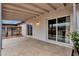 Covered patio with white brick, sliding glass doors, concrete flooring, offering an outdoor area with access to the yard at 1210 E Harmony Cir, Mesa, AZ 85204