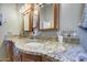 Close up on the granite counter top of the bathroom vanity, with double sinks, framed mirrors, and silver hardware at 13214 S 39Th St, Phoenix, AZ 85044