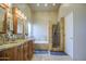 Bright bathroom with a double sink vanity, soaking tub, and glass-enclosed shower with neutral stone at 13214 S 39Th St, Phoenix, AZ 85044