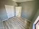 Bedroom with laminate flooring, neutral walls, large closet doors, and natural light at 13517 N 102Nd Pl, Scottsdale, AZ 85260