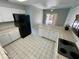 Bright kitchen featuring white cabinets, tile flooring and a black refrigerator at 13517 N 102Nd Pl, Scottsdale, AZ 85260