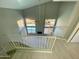 Sunlit living room overlooking the pool, with a fireplace and staircase access at 13517 N 102Nd Pl, Scottsdale, AZ 85260